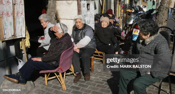 Group of elderly Shanghai women sit in the sun to keep warm during the cold winter in Shanghai, 01 February 2007. Although most of the rooms have...