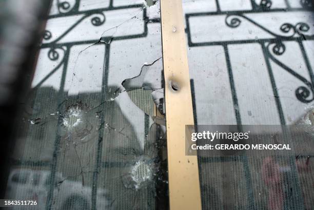 Bullet holes are seen in the window of a house where four children were killed by gunmen in Guayaquil, Ecuador, on December 12, 2023. Four children,...