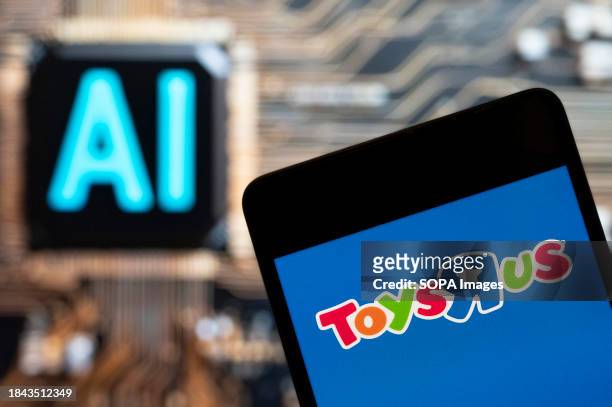 In this photo illustration, the American multinational toy chain ToysRUs logo seen displayed on a smartphone with an Artificial intelligence chip and...