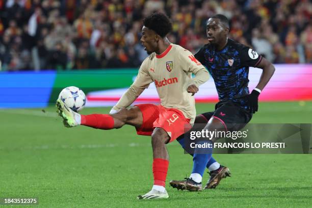 Lens' French forward Elye Wahi and Sevilla's French midfielder Boubakary Soumare fight for the ball during the Champions League football match...