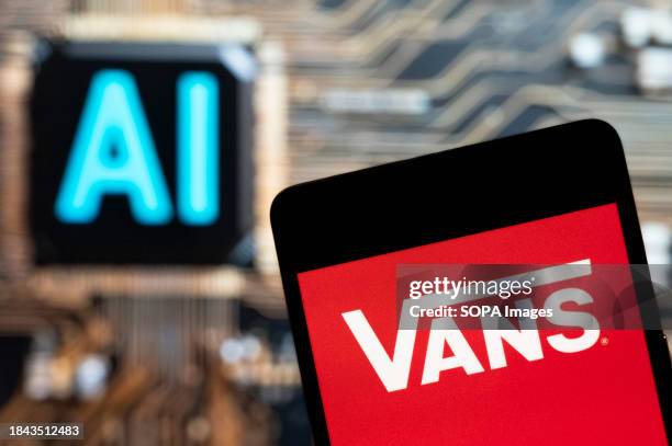 In this photo illustration, the American skateboarding shoes and clothing manufacturer Vans logo seen displayed on a smartphone with an Artificial...