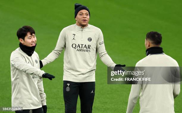 Paris Saint-Germain's French forward Kylian Mbappe reacts next to Paris Saint-Germain's South Korean midfielder Lee Kang-in and Paris Saint-Germain's...