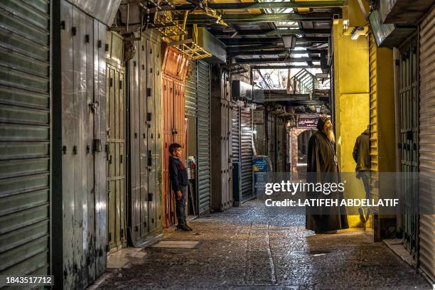 Jerusalem, Israel . People walk past closed shops during a general strike in the Old City of Jerusalem on December 11 during a general strike in...