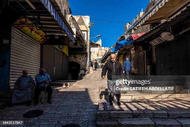 Jerusalem, Israel . People walk past closed shops during a general strike in the Old City of Jerusalem on December 11 during a general strike in...