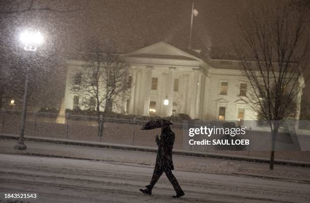 Man walks through Lafayette Park near the White House during a snowstorm in Washington, DC, on January 26, 2011. Forecasts called for up to 8 inches...