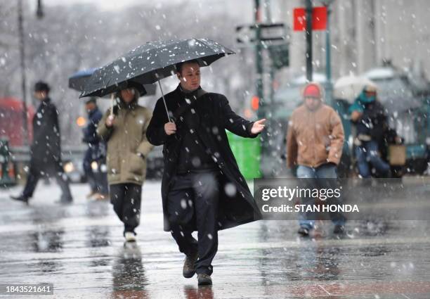 Man catches snowflakes in his hand as he walks across Foley Square in Lower Manhattan February 25, 2010 in New York AFP PHOTO/Stan Honda