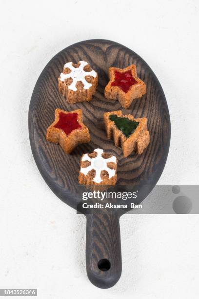 christmas. new year. festive cookies in the shape of a christmas tree, stars and snowflakes, with white marmalade filling. on a wooden board. white background. top view - rustic star stock pictures, royalty-free photos & images