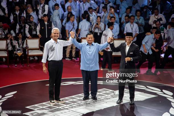 Three presidential candidates, Anies Baswedan , Prabowo Subianto , and Ganjar Pranowo , are posing for photos after the first presidential candidate...