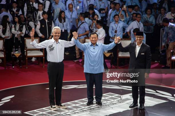 Three presidential candidates, Anies Baswedan , Prabowo Subianto , and Ganjar Pranowo , are posing for photos after the first presidential candidate...