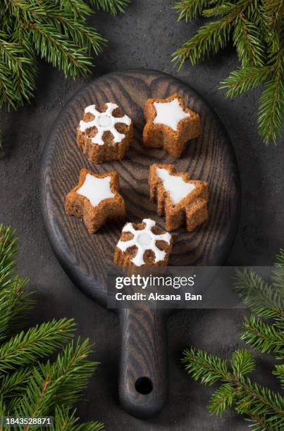 holiday cookies in the shape of a christmas tree, stars and snowflakes, with white marmalade filling. on a wooden board. dark background. top view - rustic star stock pictures, royalty-free photos & images