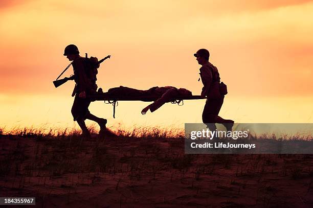 wwii  battlefield casuality evacuation by unit medics - world war ii soldier stock pictures, royalty-free photos & images