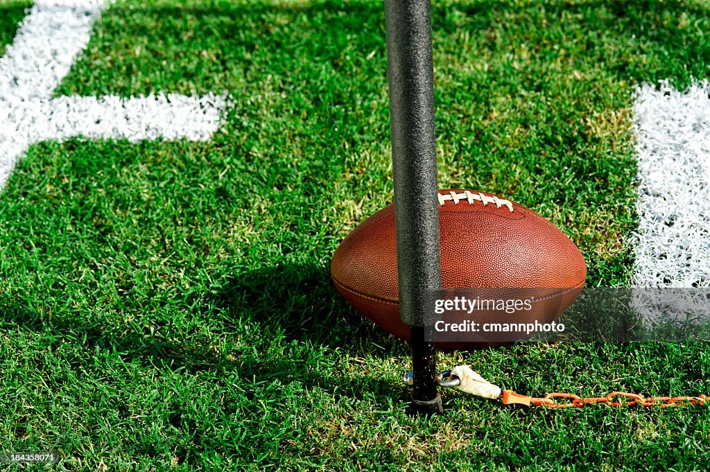 Closeup photo of an American football and first down post