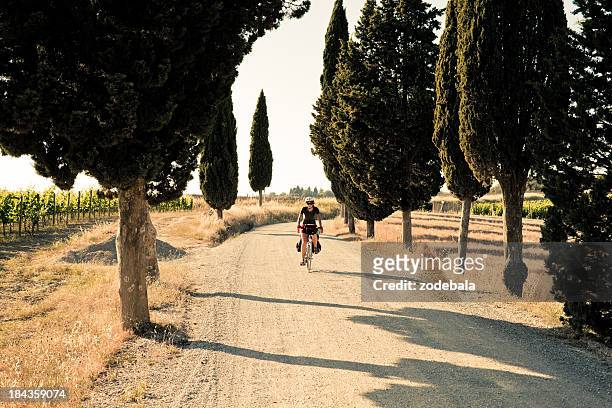 young woman riding a bike in the countryside of tuscany - tuscany stock pictures, royalty-free photos & images