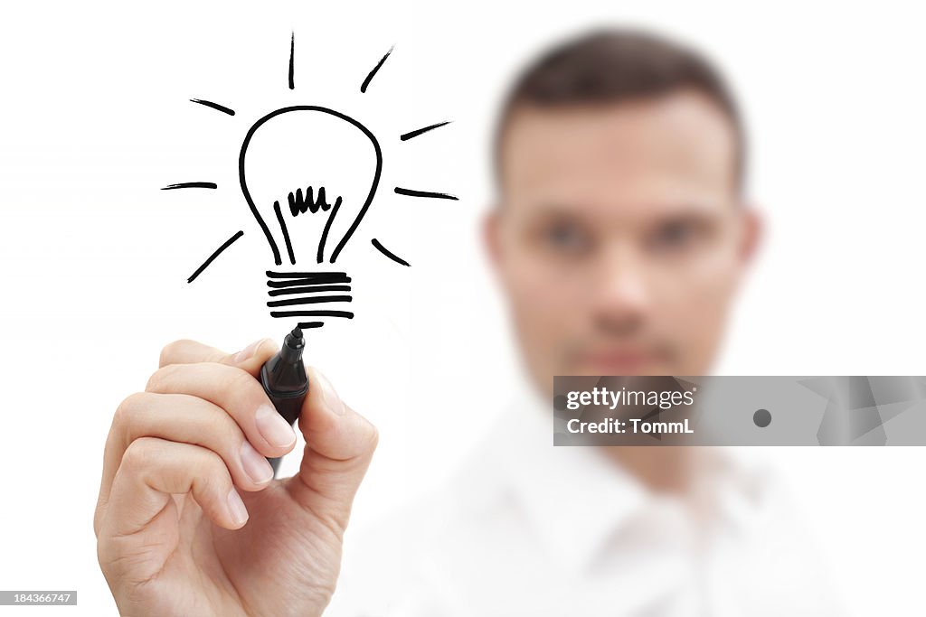 Blurred businessman drawing a lightbulb showing an idea