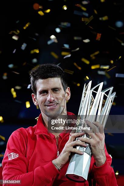 Novak Djokovic of Serbia poses with the winner's trophy after defeating Juan Martin Del Potro of Argentina during day seven of the Shanghai Rolex...