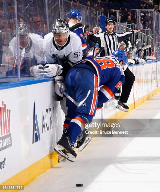 Alexander Romanov of the New York Islanders hits Quinton Byfield of the Los Angeles Kings into the boards during the first period at UBS Arena on...