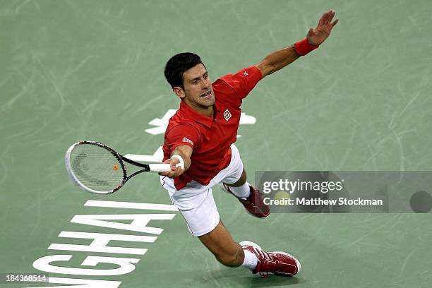 Novak Djokovic of Serbia dives for a shot while playing Juan Martin Del Potro of Argentina during the final of the Shanghai Rolex Masters at the Qi...