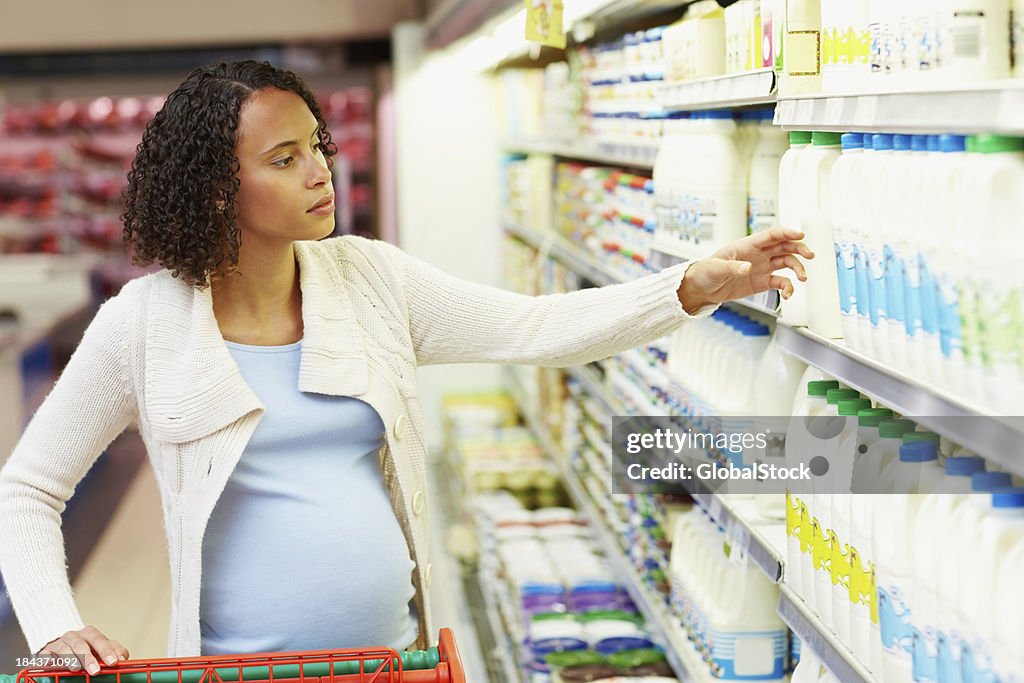 Pregnant woman buying cleaning products in super market