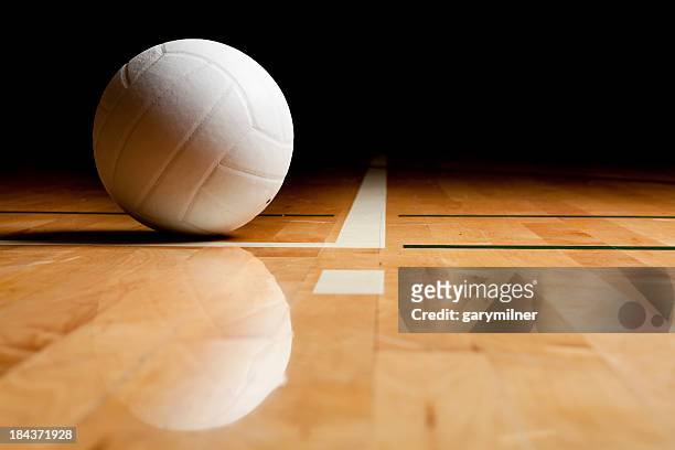 a volleyball and reflection on a wooden floor - volleybal stockfoto's en -beelden