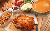 Thanksgiving Roast Turkey Dinner with Seasonal Holiday Foods in Kitchen