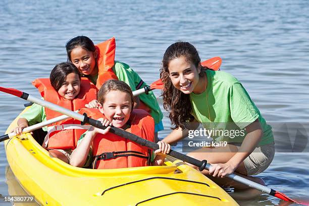 girls in a double kayak at summer camp - teens canoeing stock pictures, royalty-free photos & images