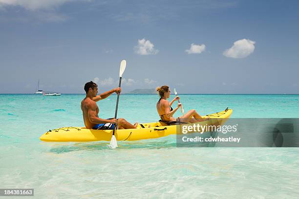 couple kayaking through the caribbean waters - ocean kayak stock pictures, royalty-free photos & images