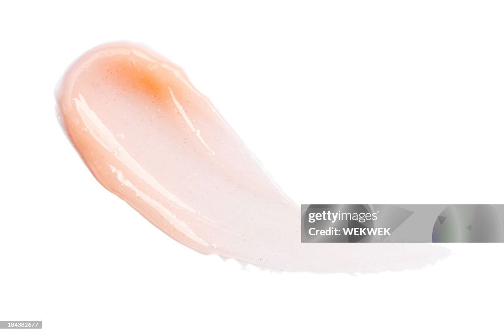 Photograph of a smear of light pink lip gloss on isolated