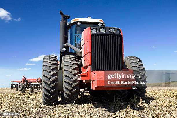 red eight tire tractor in harvested field - harrow agricultural equipment stock pictures, royalty-free photos & images