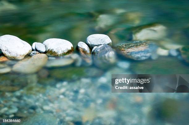 pebbles and arranged stones in river water - pebbles stockfoto's en -beelden