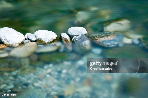 pebbles and arranged stones in river water - tranquil scene stock pictures, royalty-free photos & images