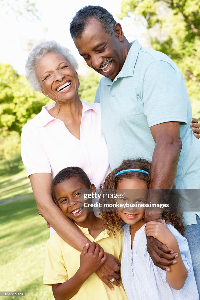 African American Grandparents With Grandchildren Walking In Park