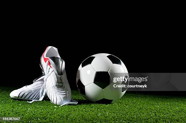 soccer ball and boots on grass - football boot stock pictures, royalty-free photos & images