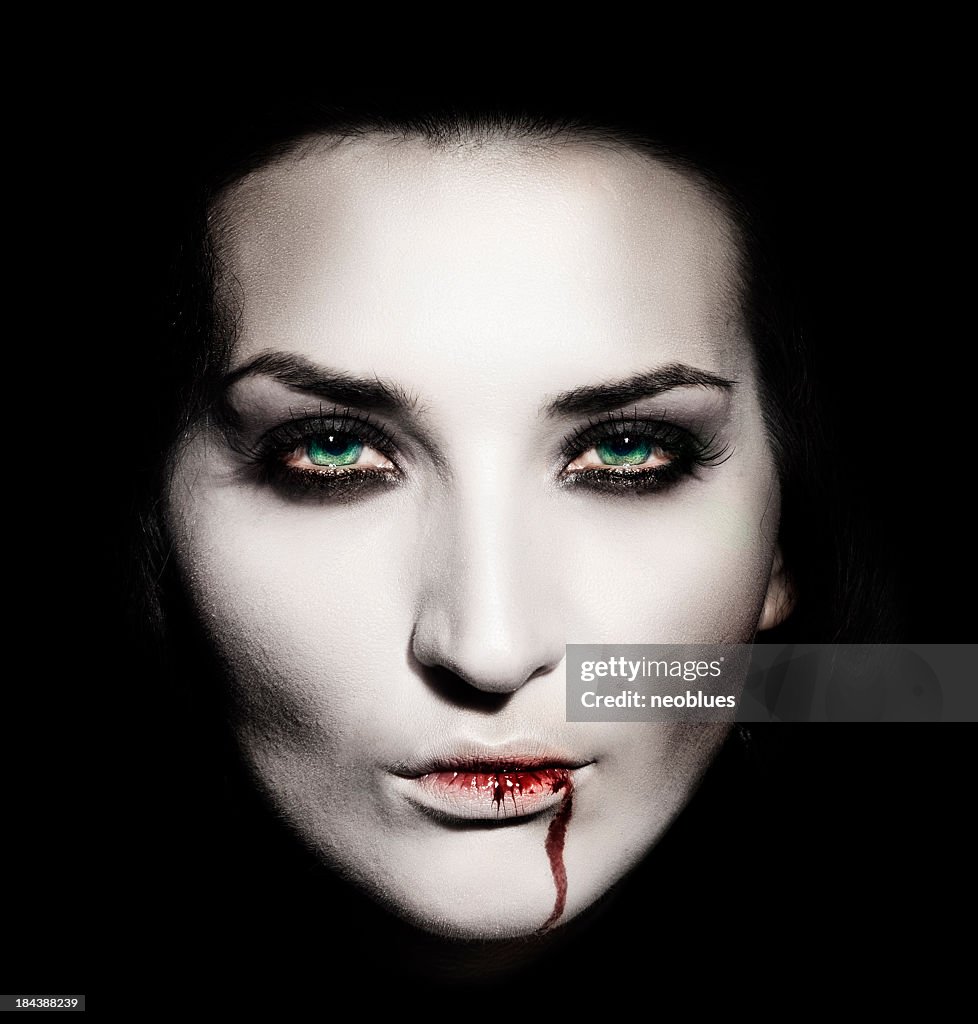 Shaded portrait of a white faced female vampire with blood