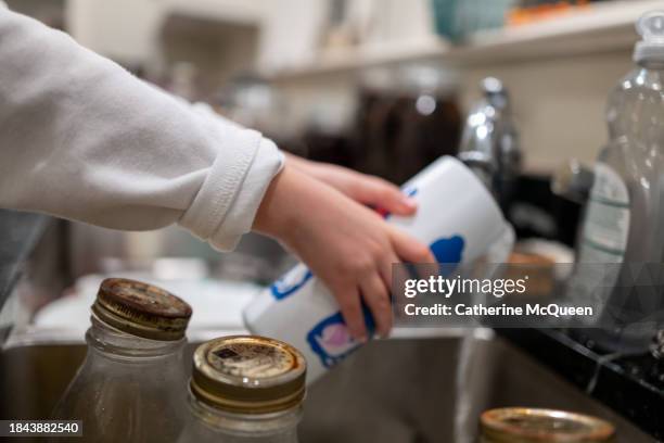 young multiracial girl fills reusable bottle with water at kitchen sink - girl filling water glass stock pictures, royalty-free photos & images