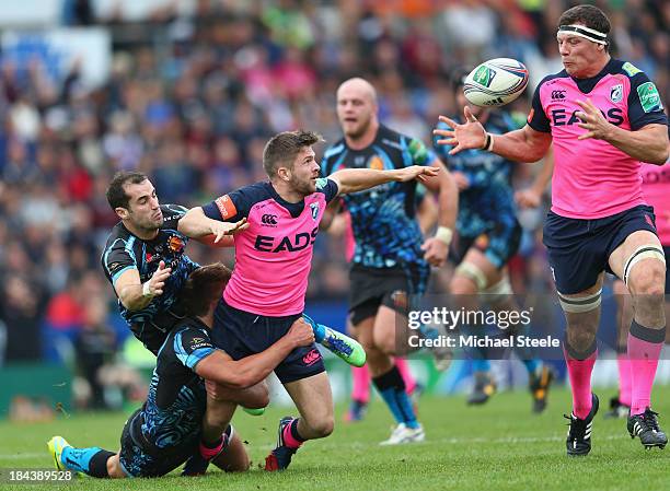 Harry Robinson of Cardiff Blues offloads to Robin Copeland as Haydn Thomas and Henry Slade of Exeter Chiefs challenge during the Heineken Cup Pool...