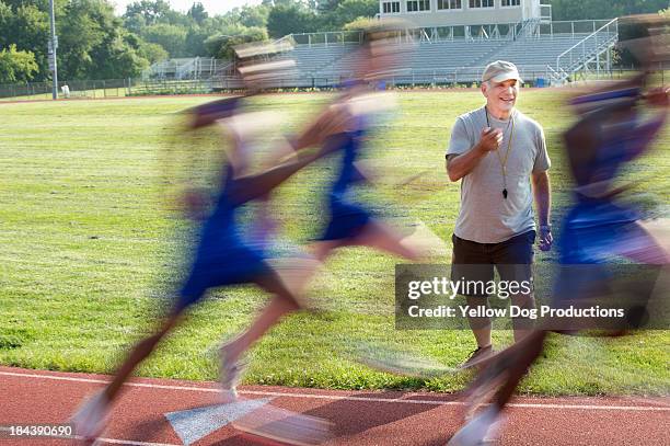 coach records time of runners on track - boy running track stock pictures, royalty-free photos & images