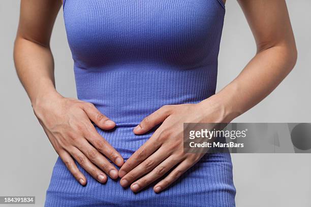 pain or cramps in stomach - woman holding tummy bildbanksfoton och bilder