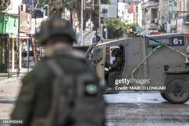 An Israeli army patrol jeep controls access to the entrance of the Jenin refugee camp in the occupied West Bank on December 13 amid ongoing battles...