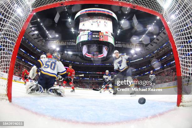 Anthony Beauvillier of the Chicago Blackhawks scores a goal past Jordan Binnington of the St. Louis Blues during the first period at the United...