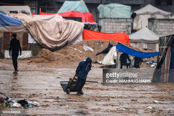Palestinian drags brickes at a camp for displaced people in Rafah, in the southern Gaza Strip where most civilians have taken refuge, on December 13...