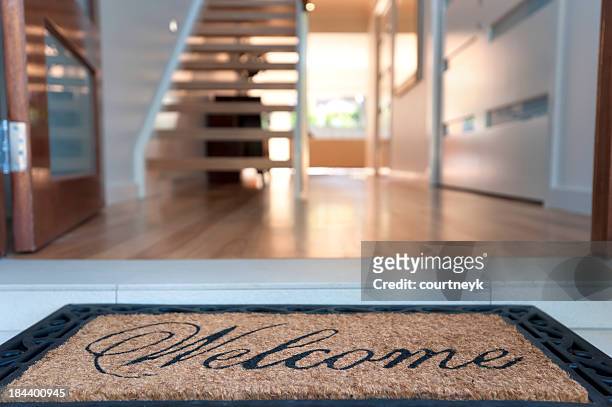 gros plan d'un tapis de bienvenue dans une maison accueillante - panneau de bienvenue photos et images de collection
