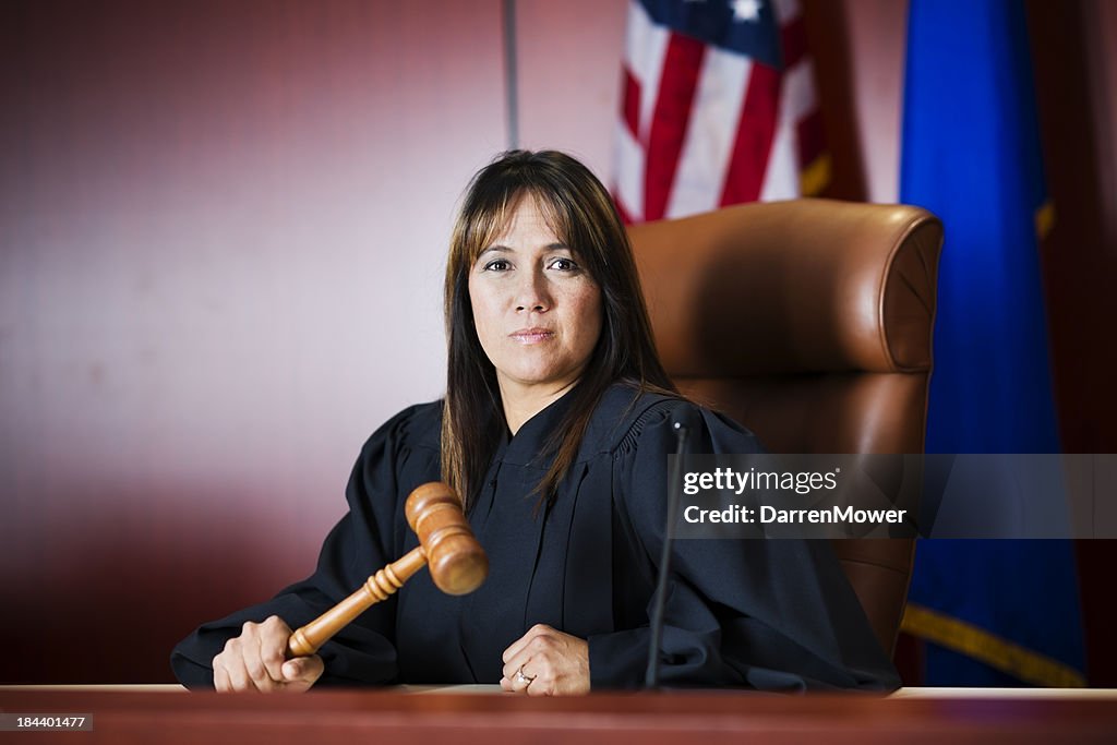 Female judge sitting in court holding her gavel