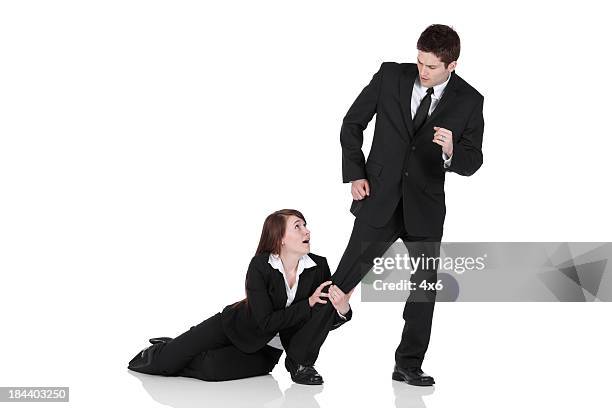 busiesswoman holding the leg of a businessman - pleading stock pictures, royalty-free photos & images