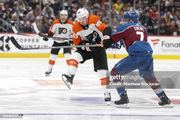 Cam Atkinson of the Philadelphia Flyers is checked by against Devon Toews the Colorado Avalanche in the third period at Ball Arena on December 09,...