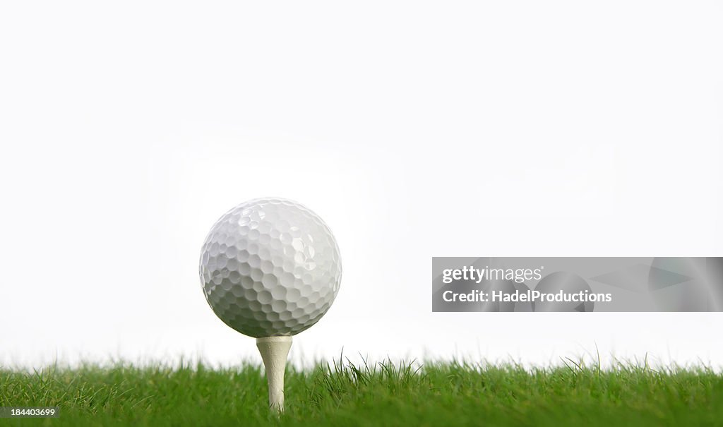 White Golf Ball and tee on green grass