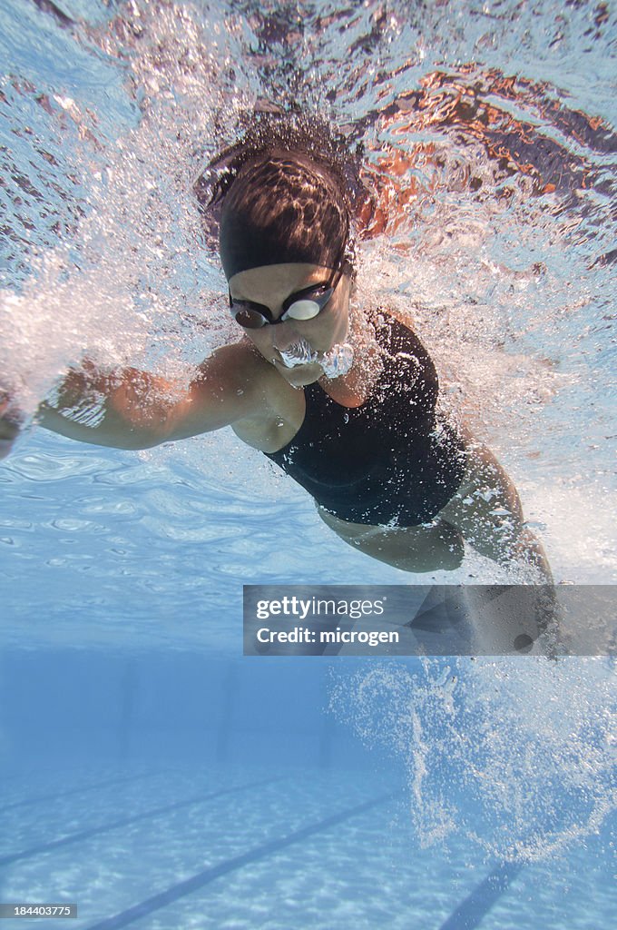 Front crawl swimmer speeding through the pool