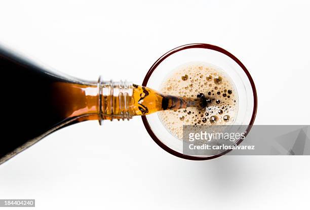 a glass of cola being poured into a glass - cola stockfoto's en -beelden