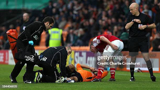 Brett Omerod of Wrexham and referee Nick Kinseley check on Curtis Weston of Barnet as he receives medical attention for a serious leg injury...