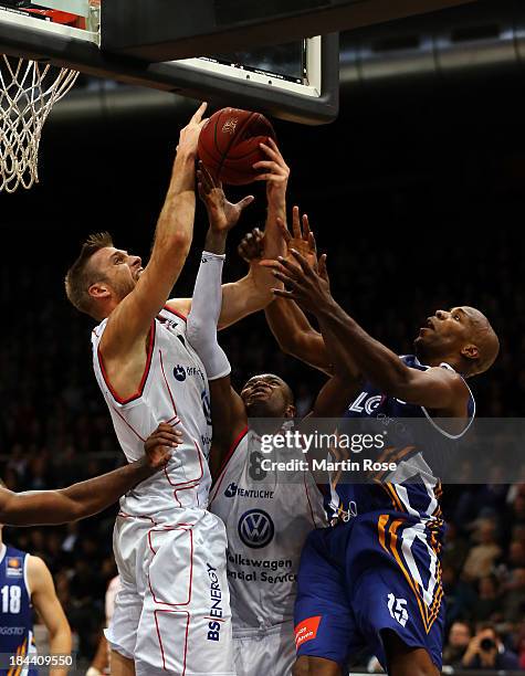 Erik Land and Harding Nana of Braunschweig and Derrick Allen of Bremerhaven compete for the ball during the Beko Basketball Bundesliga match between...