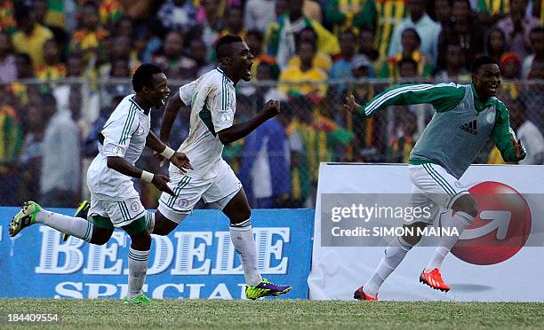 Nigeria's Emmanuel Emenike celebrates with teammates Eddy Onazi and James Okwuosa on October 13, 2013 after defeating Ethiopia in a 2014 World Cup...